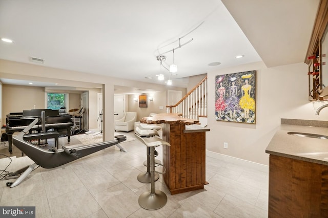 interior space featuring a kitchen breakfast bar, sink, and light tile patterned floors