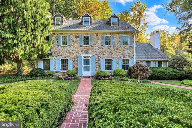 colonial inspired home with a front lawn