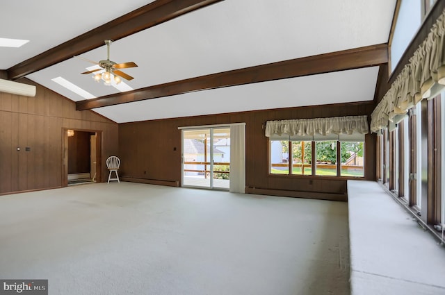 unfurnished living room with vaulted ceiling with skylight, wood walls, a baseboard radiator, and ceiling fan