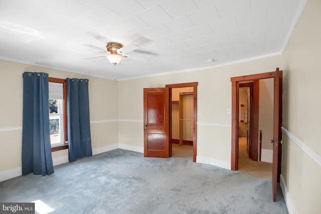 unfurnished room with ornamental molding, carpet flooring, and ceiling fan