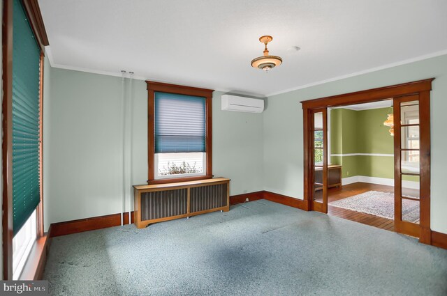 empty room featuring radiator, crown molding, hardwood / wood-style flooring, and a wall unit AC