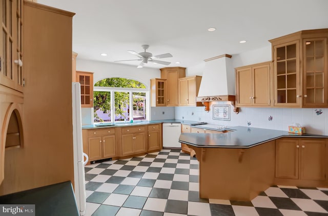 kitchen featuring decorative backsplash, kitchen peninsula, custom range hood, white dishwasher, and ceiling fan