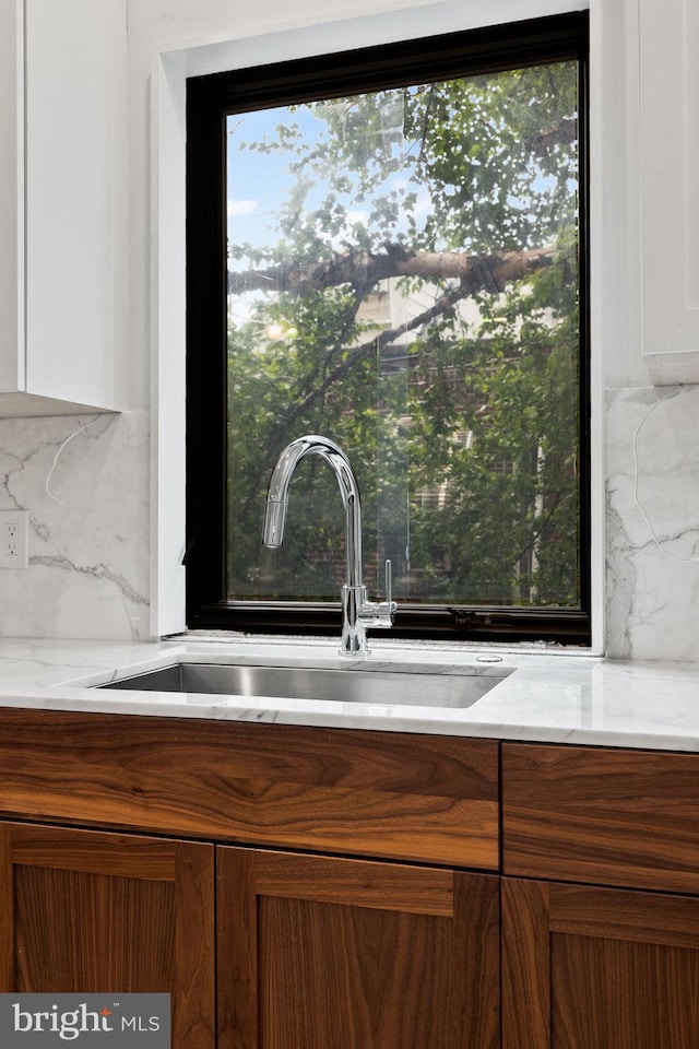 706 Latona St Unit J, Philadelphia, PA 19147 - detailed view of a sink, decorative backsplash, light stone counters, and white cabinets