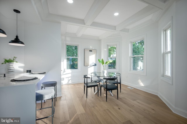 dining space featuring coffered ceiling, beamed ceiling, and light hardwood / wood-style floors