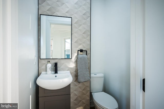 bathroom featuring tile walls, vanity, and toilet