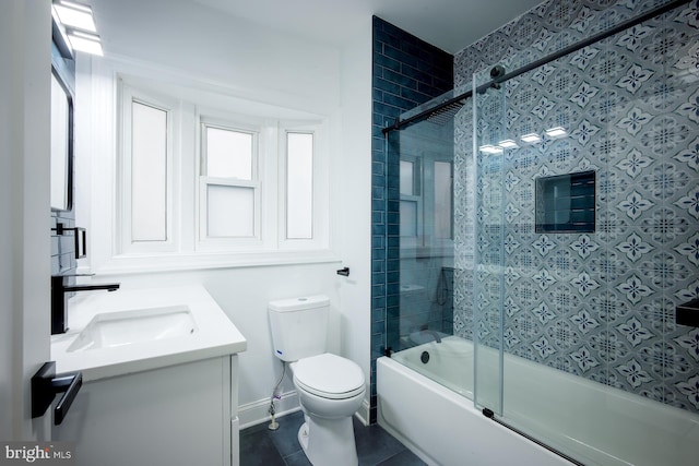 full bathroom featuring tile patterned floors, toilet, vanity, and bath / shower combo with glass door