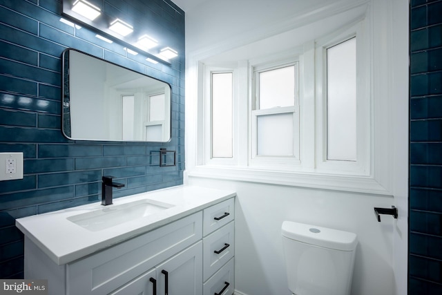 bathroom featuring decorative backsplash, vanity, and toilet