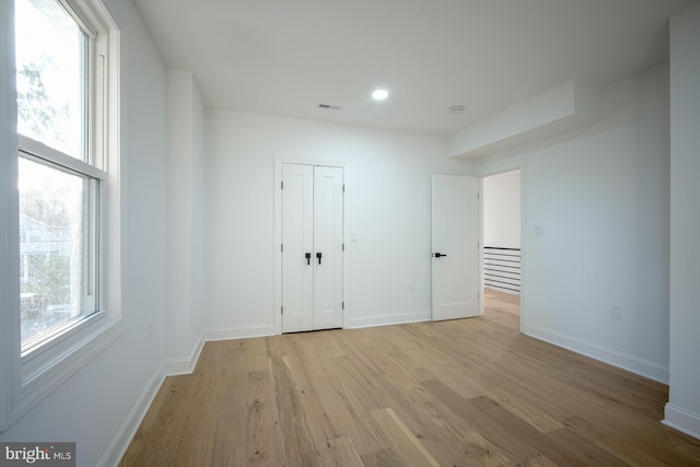 unfurnished bedroom with a closet and light hardwood / wood-style floors