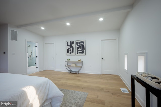 bedroom featuring beamed ceiling, light wood-type flooring, and ensuite bathroom