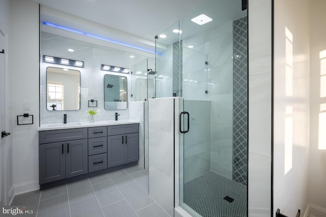 bathroom featuring tile patterned flooring, an enclosed shower, and vanity