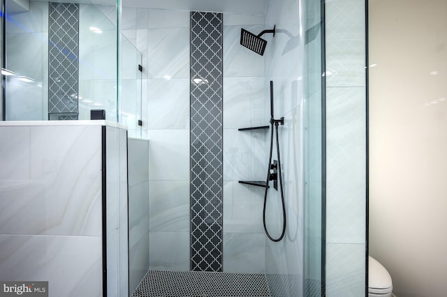 bathroom featuring a tile shower and toilet