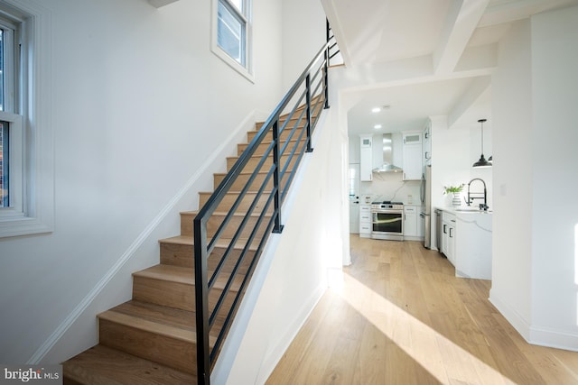 staircase featuring hardwood / wood-style floors and sink