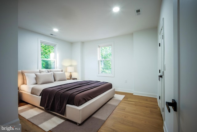 bedroom featuring light hardwood / wood-style flooring and multiple windows