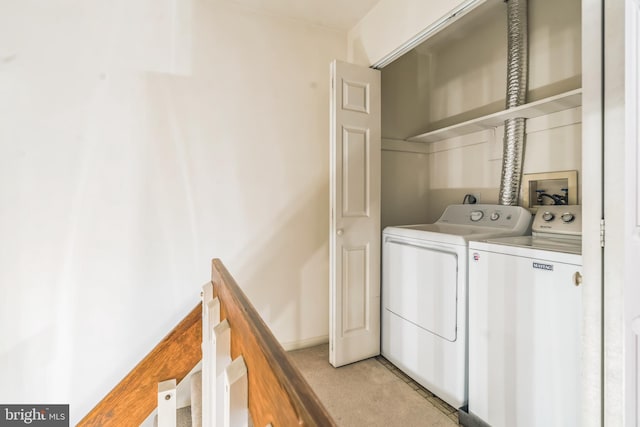 clothes washing area featuring light colored carpet and separate washer and dryer