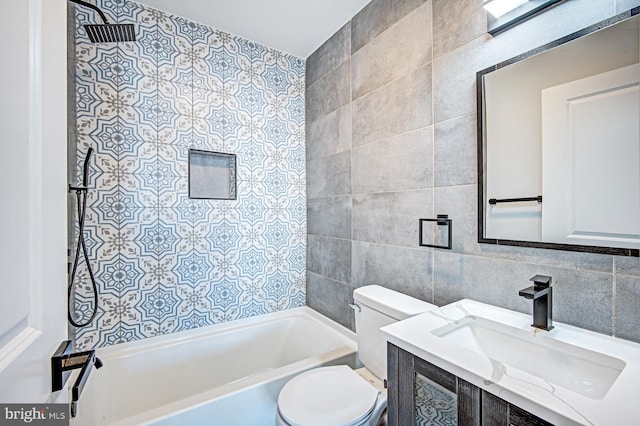 full bathroom featuring tile walls, decorative backsplash, vanity, tiled shower / bath, and toilet