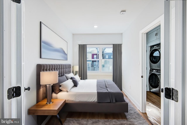 bedroom with hardwood / wood-style floors and stacked washer / drying machine