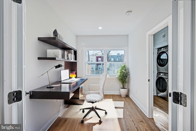 office space featuring light hardwood / wood-style floors and stacked washer and dryer