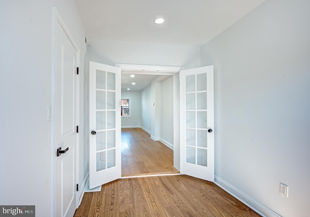 corridor featuring wood-type flooring and french doors