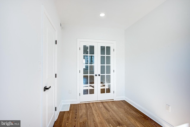 spare room featuring wood-type flooring and french doors