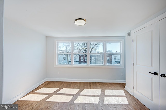 unfurnished bedroom with light hardwood / wood-style flooring and a closet