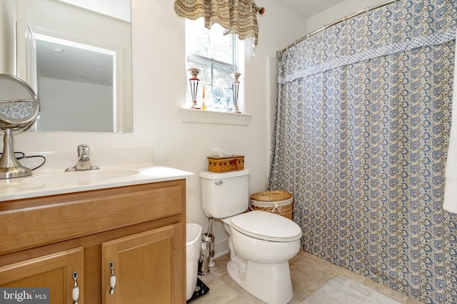 bathroom featuring walk in shower, vanity, toilet, and tile patterned floors