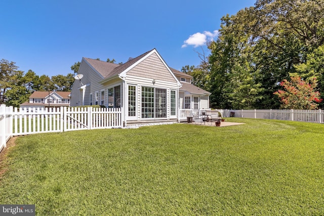 rear view of house with a yard and a patio