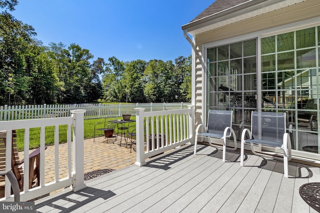 wooden terrace featuring a lawn