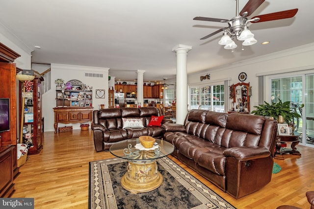 living room featuring ceiling fan, ornamental molding, light hardwood / wood-style floors, and ornate columns