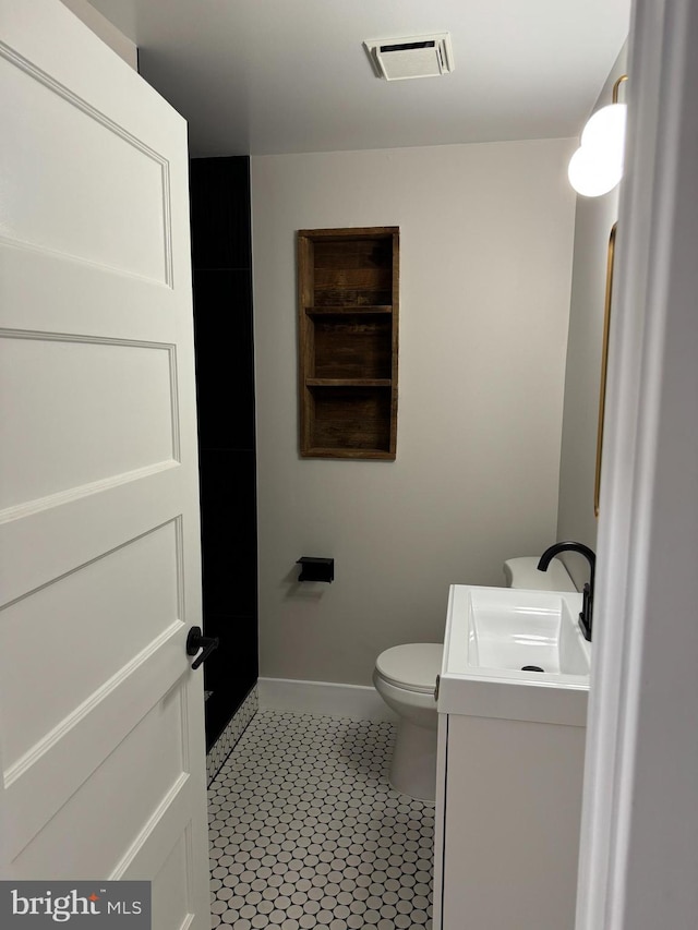 bathroom featuring vanity, tile patterned flooring, and toilet