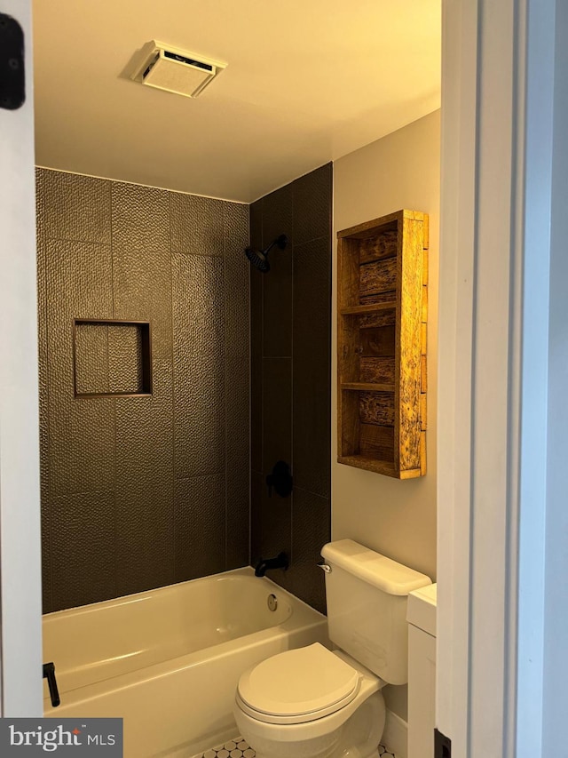 bathroom with tiled shower / bath combo, toilet, and tile patterned flooring