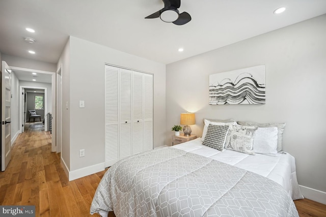 bedroom with hardwood / wood-style flooring, ceiling fan, and a closet