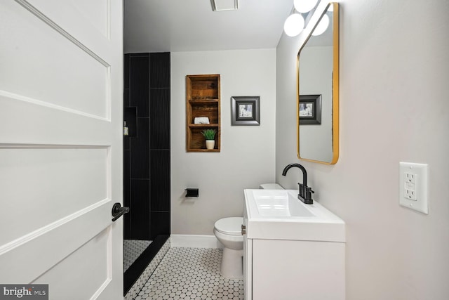 bathroom with tile patterned floors, vanity, toilet, and a shower