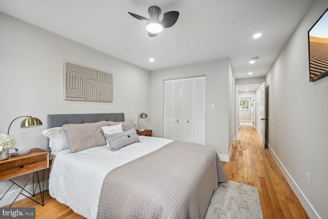 bedroom with a closet, light hardwood / wood-style flooring, and ceiling fan