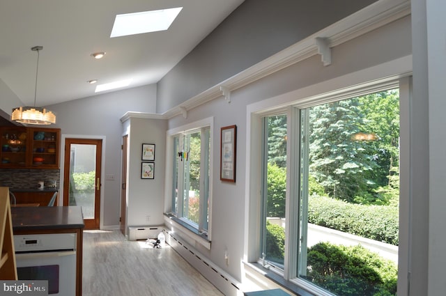 kitchen featuring tasteful backsplash, wood-type flooring, oven, a baseboard heating unit, and lofted ceiling with skylight