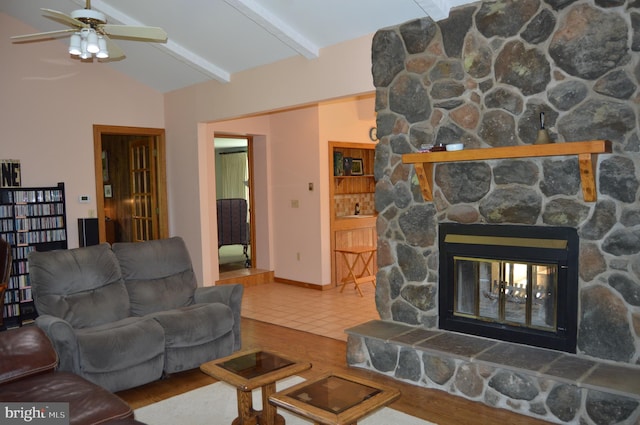 living room featuring wood-type flooring, a fireplace, lofted ceiling with beams, and ceiling fan