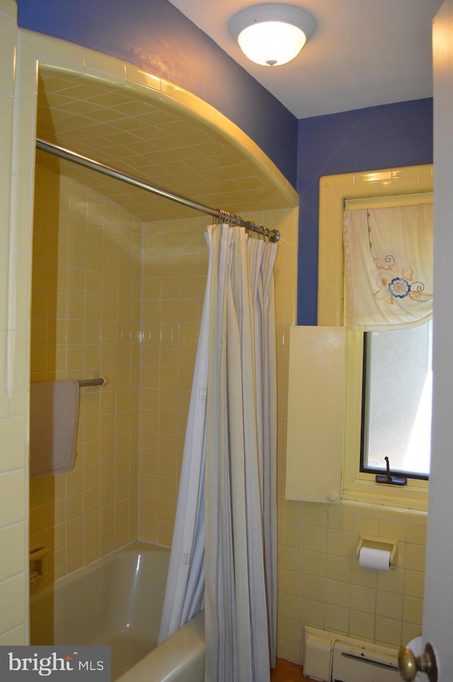 bathroom featuring tile walls, baseboard heating, and shower / bathtub combination with curtain