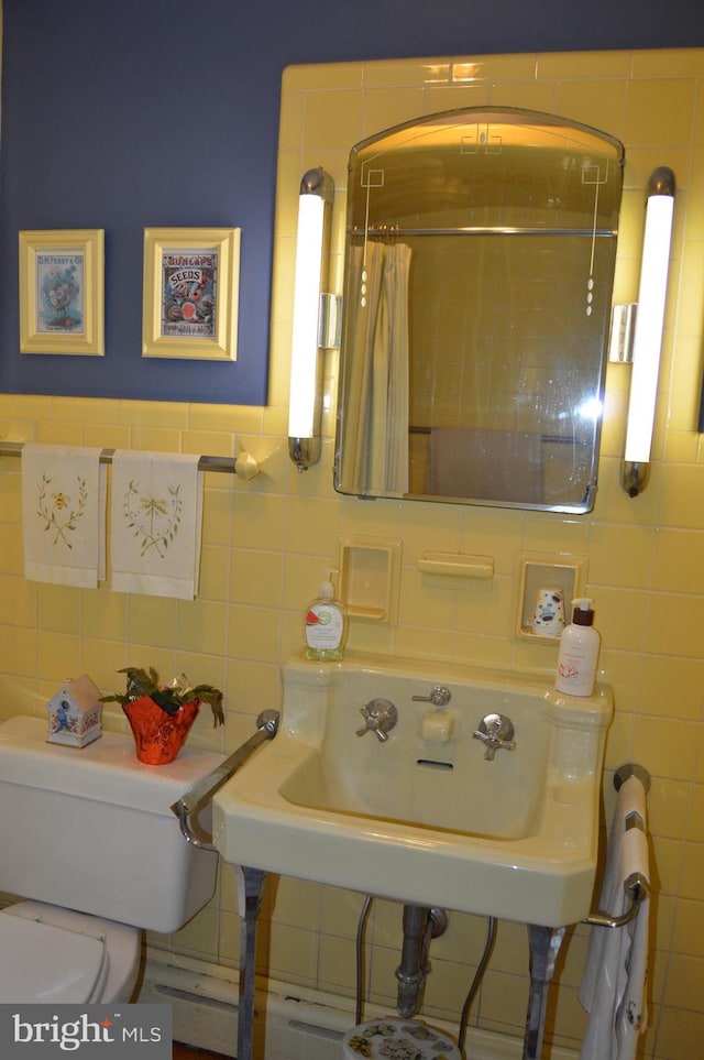 bathroom featuring tile walls and toilet