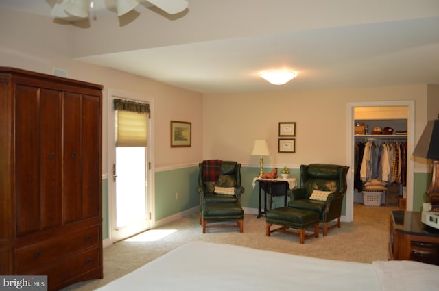 carpeted bedroom with a spacious closet, a closet, and ceiling fan