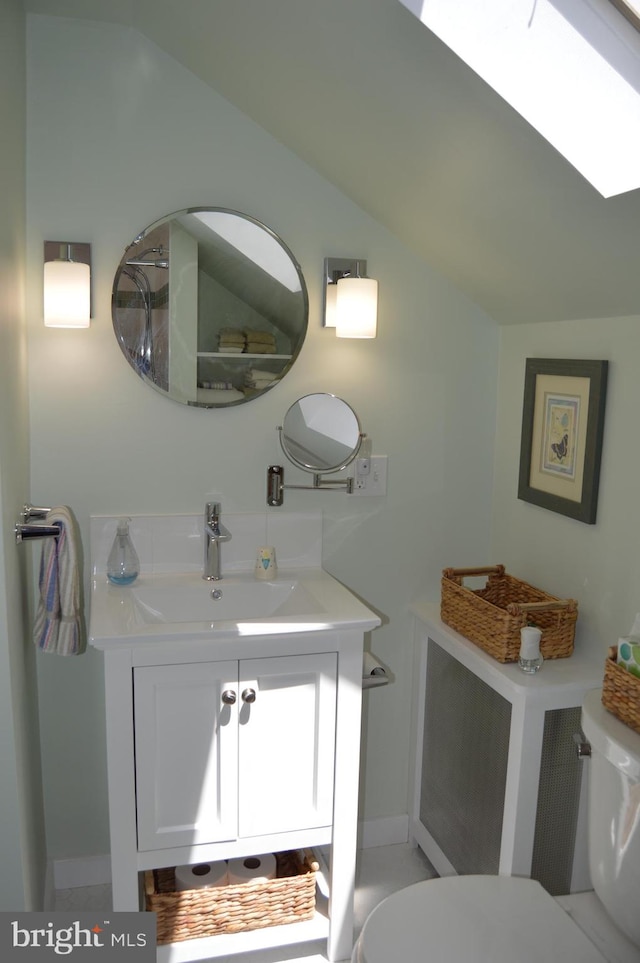 bathroom with vaulted ceiling, vanity, and toilet