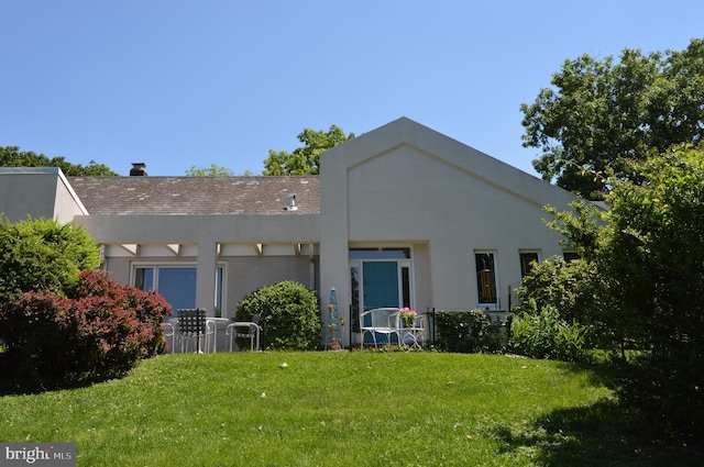 rear view of house featuring a yard