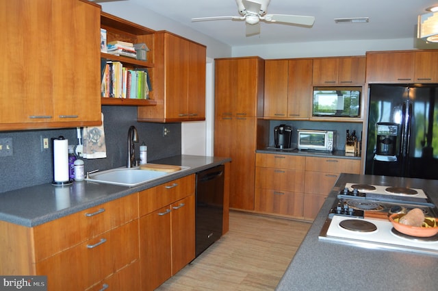 kitchen with sink, light hardwood / wood-style flooring, decorative backsplash, black appliances, and ceiling fan