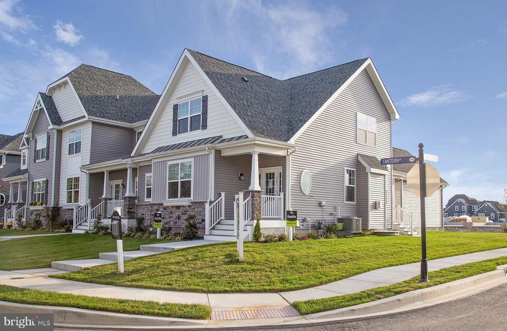 view of front of property with a front yard, a porch, and central air condition unit