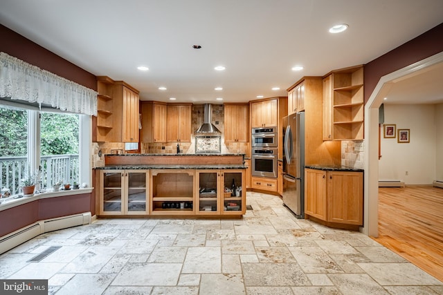 kitchen with dark stone counters, appliances with stainless steel finishes, tasteful backsplash, and wall chimney range hood