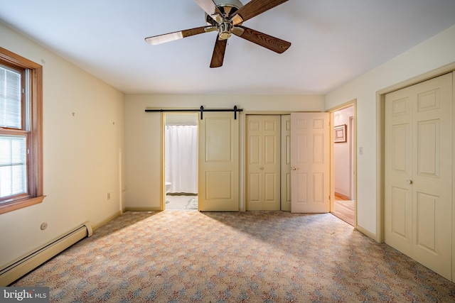 unfurnished bedroom with ceiling fan, light colored carpet, baseboard heating, and a barn door