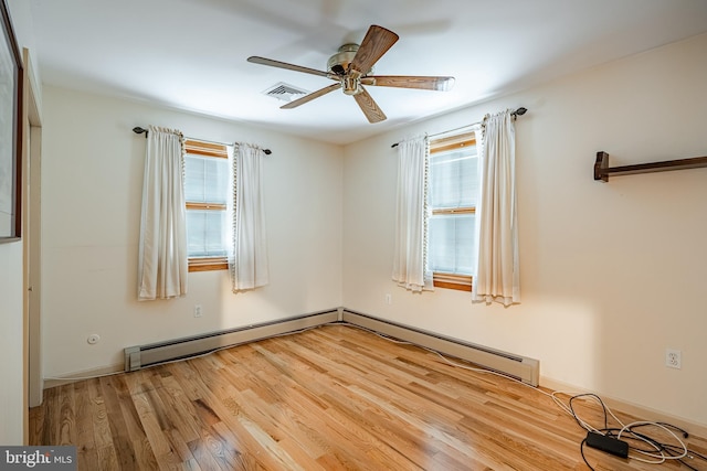 spare room with ceiling fan, a baseboard radiator, light hardwood / wood-style flooring, and a wealth of natural light