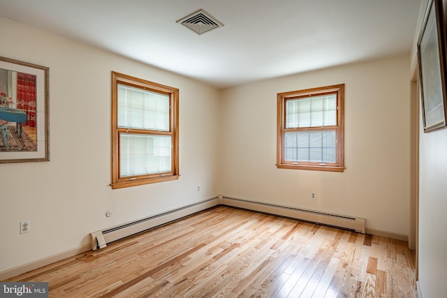 empty room featuring light hardwood / wood-style flooring and baseboard heating