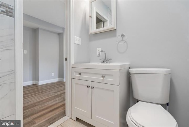 bathroom with vanity, toilet, and hardwood / wood-style flooring