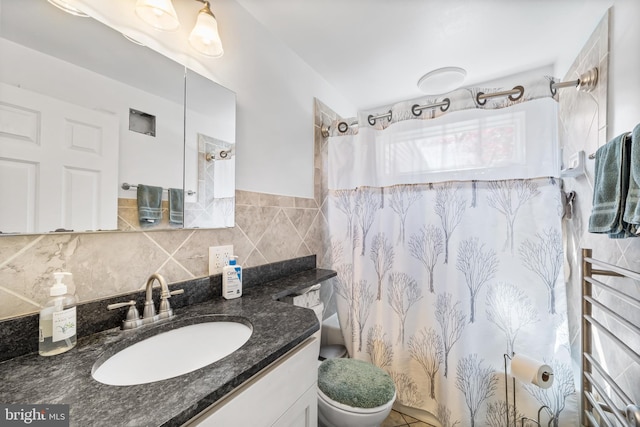 bathroom featuring curtained shower, tile walls, vanity, and toilet