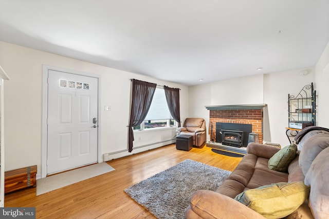 living room featuring a fireplace, baseboard heating, and light hardwood / wood-style floors