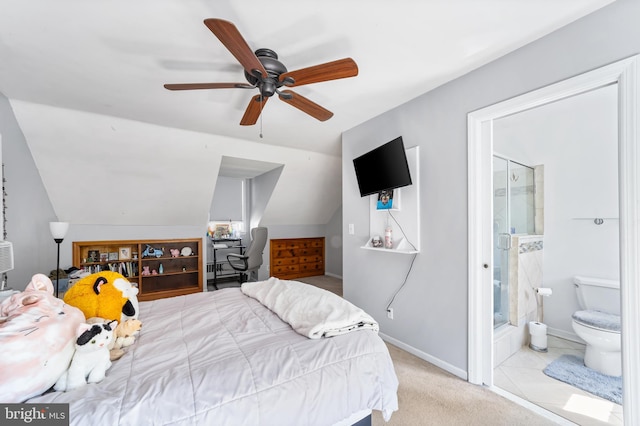 bedroom featuring ceiling fan, light colored carpet, ensuite bath, and vaulted ceiling